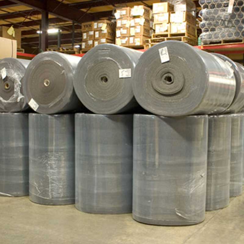 Shipping textile rolls in a warehouse stacked atop each other
