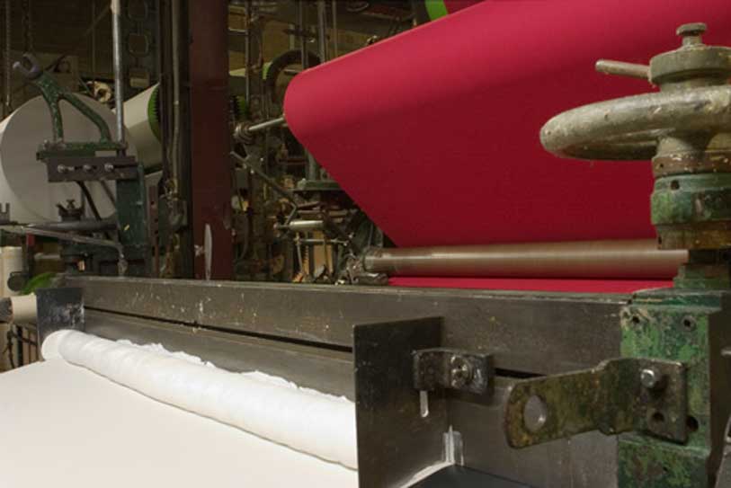 red fabric on rollers in a manufacturing machine